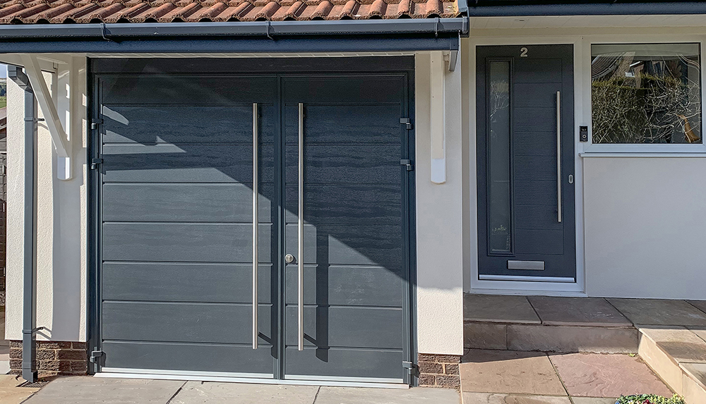 Teckentrup single centre ribbed side hinge garage door finished in anthracite grey.
