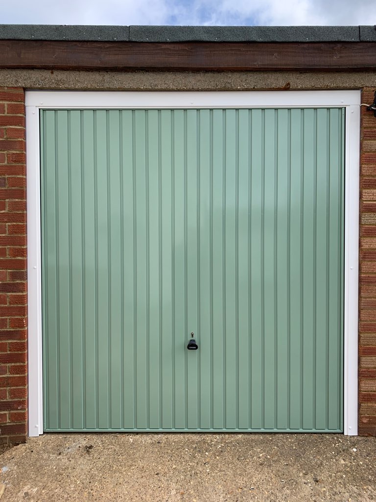 Single Steel (Chartwell Green) Vertical Canopy Garage Door with White Frame.