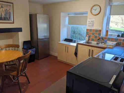 showing large fridge freezer, storage units, dining table for five, microwave and toaster