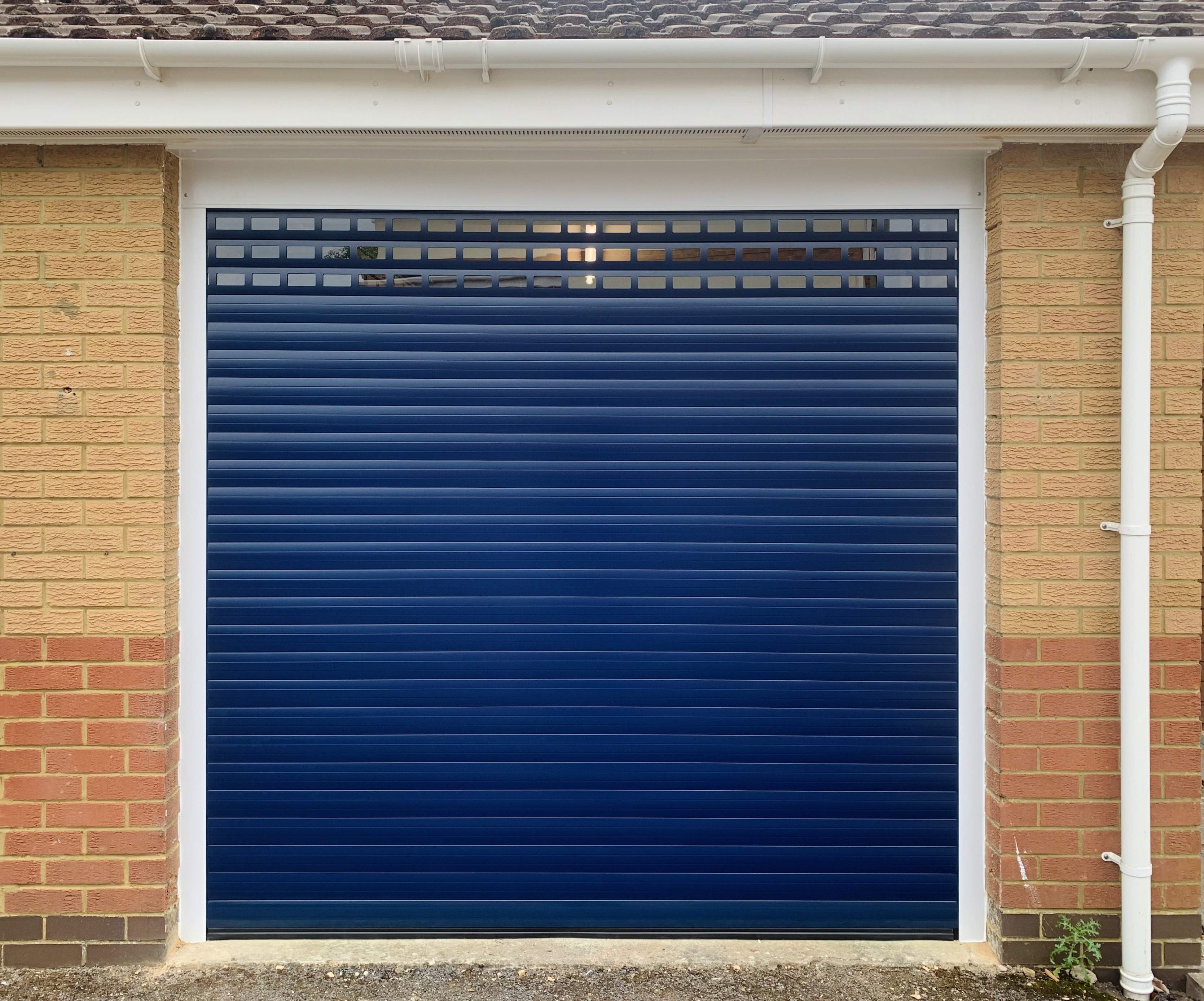Single Insulated 55mm Lath (Blue) Roller Shutter Garage Door with White Frame and windows.