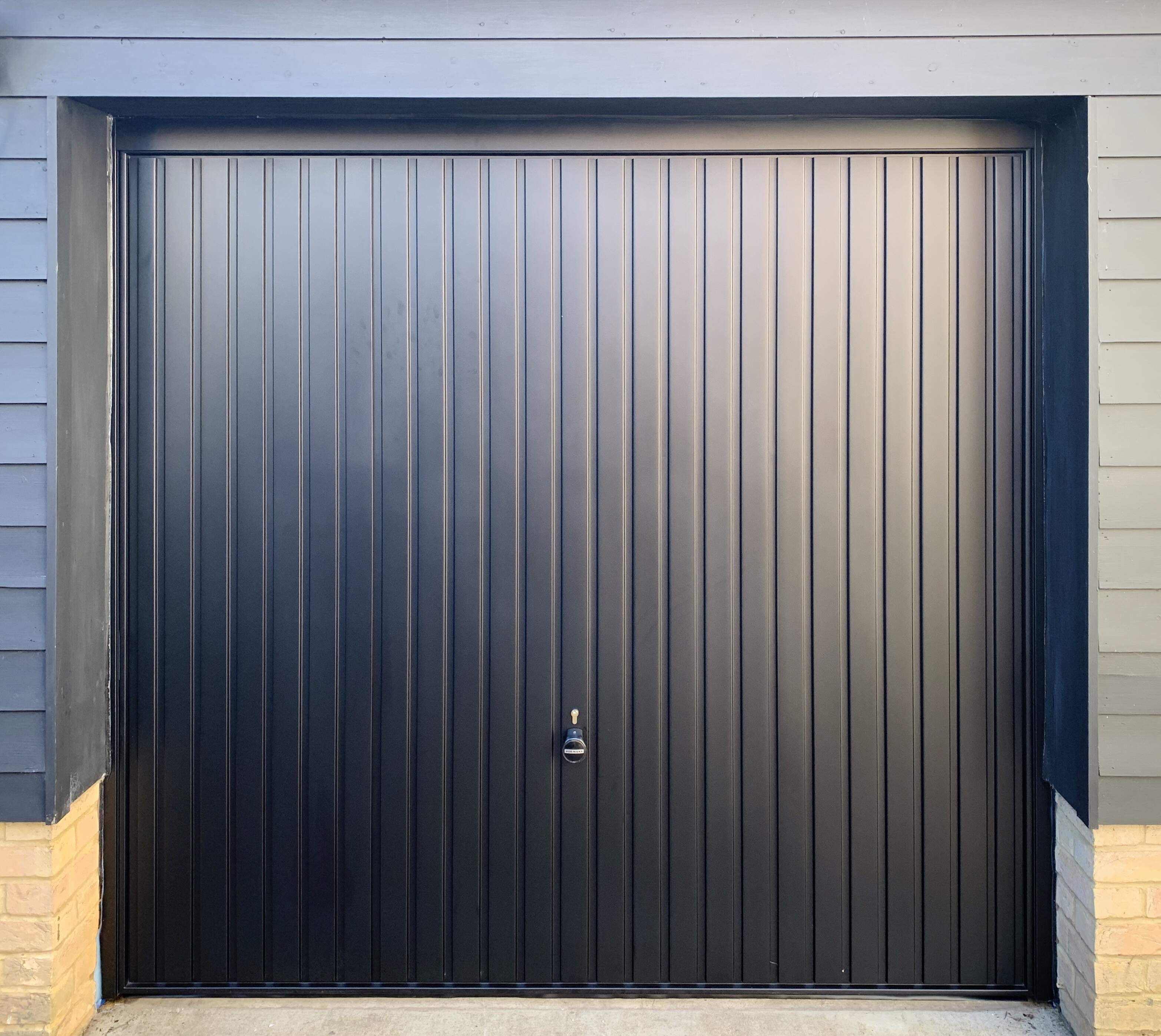 Single Steel (Black) Vertical Canopy Garage Door with Black Frame.