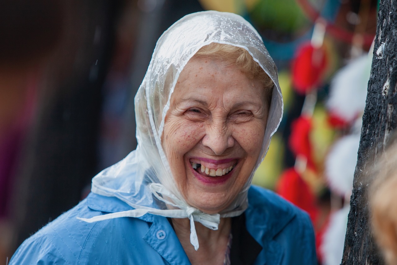 old woman in plastic rain hat